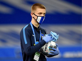 A ball boy disinfects a ball during Friday's German Bundesliga match between Hertha BSC and FC Union Berlin. The league is playing without fans in the stands following the outbreak of the novel coronavirus.