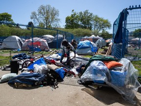 Fencing surrounds a portion of a homeless camp at Oppenheimer Park as a man disassembles a tent, in the Downtown Eastside of Vancouver, on Wednesday, May 6, 2020. The province had set a May 9 deadline to temporarily relocate hundreds of people from tent encampments in Vancouver and Victoria to hotel and community centre accommodations to protect them from the ongoing COVID-19 pandemic.