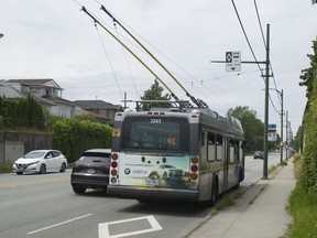 A TransLink bus travelling westbound on 41st Avenue in Vancouver. Diamonds on the street and sign above shows the lane is reserved for buses and bicycles from 7 a.m. to 7 p.m.