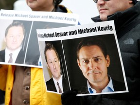 People hold signs calling for China to release Canadian detainees Michael Spavor and Michael Kovrig during an extradition hearing for Huawei Technologies Chief Financial Officer Meng Wanzhou at the B.C. Supreme Court in Vancouver, British Columbia, March 6, 2019.