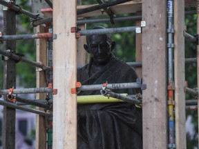 Workers erect a protective barrier around the statue of Mahatma Gandhi in Parliament Square in anticipation of protests taking place in London earlier this month.