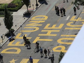 People walk down 16th street after Defund The Police was painted on the street near the White House on June 08, 2020 in Washington, DC.