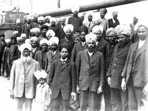 On May 23, 1914, the SS Komagata Maru arrived in Vancouver with would-be immigrants led by Indian businessman Gurdit Singh, who sought to challenge Canada's exclusionary immigration policy towards Asians. The 376 passengers were denied entry to Canada, and had to remain on the ship for two months before being forced to leave under armed escort on July 23rd. Gurdit Singh is the man with a white beard wearing a light coloured suit in the left foreground, while Puran Singh is fourth from left in the front row. This photo ran on the front page of the Province on May 26, 1914. Leonard Frank photo, Vancouver Public Library 6231