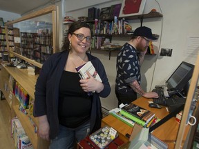 Hilary Atleo (left), owner of Iron Dog Books, and staff member Duncan Parizeau, at their Vancouver store. Plexiglass barriers surround the sales counter at the store, and are a common sight in the retail sector these days due to the COVID-19 pandemic.