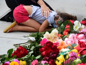 A child is consoled while grieving as protesters gather to place roses in front of the Hall of Justice in Los Angeles, California, on June 5, 2020 in solidarity with victims of alleged state violence inside and outside of LA County's jail system.