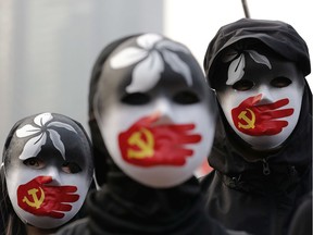 People wearing masks stand during a rally to show support for Uighurs and their fight for human rights in Hong Kong.