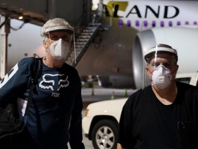 Canadian director James Cameron (L) and U.S. producer Jon Landau pose for a photo, while arriving at Wellington International Airport to resume the filming of the Avatar sequels, as New Zealand eases restrictions imposed over the global outbreak of the coronavirus disease (COVID-19), in Wellington, New Zealand, May 31, 2020.