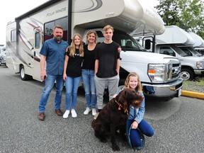 From left, Griffin Augustin with Cloey, wife Heather, Brady and Lily and the RV they just used on a two-week trip around the province.