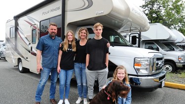 From left, Griffin Augustin with Cloey, wife Heather, Brady and Lily and the RV they just used on a two-week trip around the province.