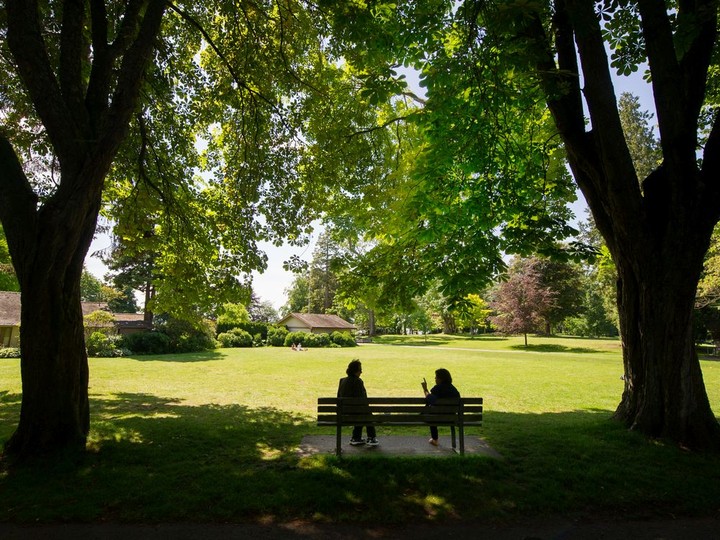  Two ladies chat on a bench as they enjoy the weather in Stanley Park in this file photo.