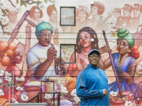 Lama Mugabo with mural (artist Ejiwa "Edge" Ebenebe depicting life of Hogan's Alley) on the wall of Nora Hendrix Place in Vancouver,  June 30, 2020.
