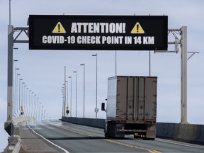 A sign indicates that provincial health department workers will stop traffic that has crossed the Confederation Bridge in Cape Jourimain, N.B., on March 22.