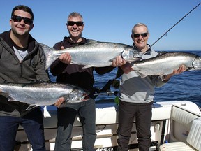 Three generation haul. Alex MacNaull, left, his dad, Steve, and his grandpa, Bob, show off their catch of Chinook salmon.