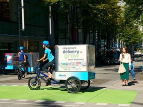 A delivery person is pictured riding a cargo e-bike in downtown Vancouver, B.C. in this undated handout photo.