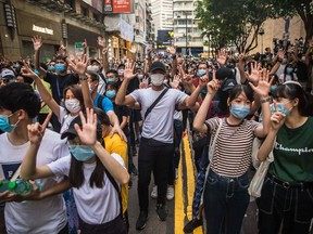 Protesters chant slogans during a rally against a new national security law in Hong Kong on July 1, 2020, on the 23rd anniversary of the city's handover from Britain to China. Hong Kong police made the first arrests under Beijing's new national security law on July 1 as the city greeted the anniversary of its handover to China with protesters fleeing water cannon.