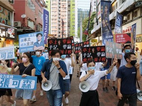 Sam Cheung Ho-sum and Wong Ji-yuet march on a street to campaign for the primary election aimed at selecting democracy candidates for the September election, in Hong Kong, China July 12, 2020.