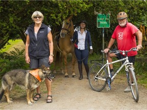 From left, Jennifer Maynard, Whitney Santos and Larry Emrick at the End of Trail sign posted at west border of Marine Drive Golf Club. The private club won't negotiate a right-of-way with the city that would complete the beautiful Fraser River Trail.