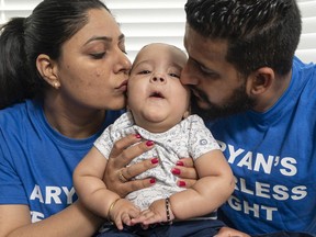 Harpreet (left) and Gaganpreet Deol kiss their baby Aryan for a family photo at their home in Surrey, BC, July, 19, 2020. Baby Aryan Deol has type 1 spinal muscular atrophy, and his family is raising funds for an expensive but promising treatment.