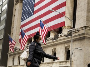 A pedestrian with a mask walks past of the New York Stock Exchange (NYSE) in New York, U.S., March 18, 2020.