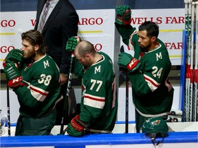 Matt Dumba of the Minnesota Wild raises his fist during the national anthem before a qualification round game against the Vancouver Canucks at Rogers Place in Edmonton on Aug. 7.