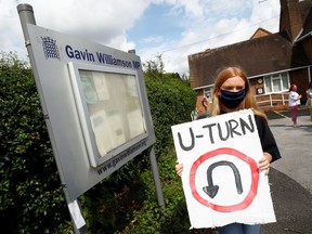 An A-level student holds a placard as she protests the exam results at the constituency offices of Education Secretary Gavin Williamson, in South Staffordshire, U.K., on Aug. 17.