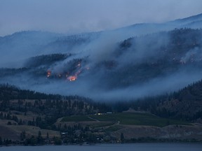 Flames and smoke are seen from the Christie Mountain wildfire along Skaha Lake near Penticton on Thursday.