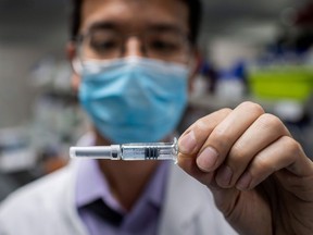 An engineer displays an experimental vaccine for the COVID-19 virus earlier this year. Biomedical engineers are accelerating and scaling-up the production of vaccines and the way they're delivered.