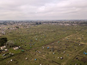 Aerial view showing tents and improvised shelters set up by homeless people in vacant land outside Guernica, in the province of Buenos Aires, south of the Argentine capital, on Aug. 28, 2020 amid rising poverty in an economic crisis exacerbated by the COVID-19 pandemic.