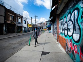 A person walks by a closed business in the Kensington Market neighbourhood of Toronto in April.