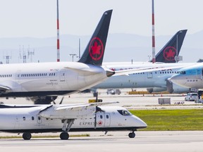Air Canada planes sit on the runway at Vancouver International Airport.