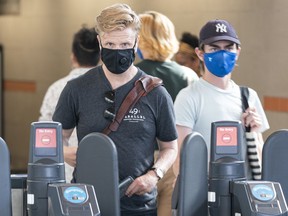 Transit users wearing masks as they leave the Broadway-City Hall Station on the Canada Line on Monday.