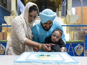 Baby Aryan Deol with the help of his mother Harpreet and father Gagan cuts a cake to celebrate his first birthday and for achieving the fundraising goal for his medical treatment in Surrey on Sunday. Aryan has SMA and needs drug Zolgensma which costs $2.8 million.