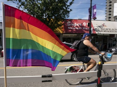 A cyclist rides past a rainbow flag on Davie Street in Vancouver, BC, August, 2, 2020.