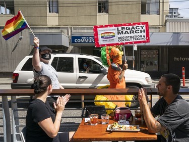 Diners at a restaurant along Davie Street clap in support of the Pride 2020 Legacy March in Vancouver, BC, August, 2, 2020.