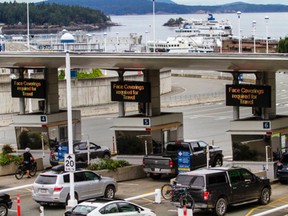 Motorists at the Swartz Bay ferry terminal fare booths, where signs remind passengers about the need for face masks.