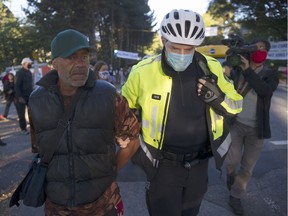 Peter Portuondo was handcuffed by Vancouver police and led away from a demonstration across from Strathcona Park in Vancouver on Sept. 29 but was released after a few minutes. Portuondo had kicked a vehicle that crowded demonstrators in a crosswalk during a protest by area residents frustrated with a tent city in the park.