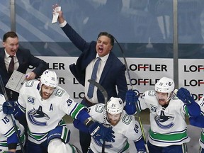Canucks head coach Travis Green celebrates his team’s 5-4 overtime win against the Minnesota Wild in Game 4 and the Western Conference Qualification Round prior to the 2020 NHL Stanley Cup Playoffs at Rogers Place on Aug. 7, 2020, in Edmonton.