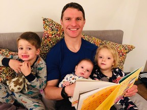 Vancouver Canuck Antoine Roussel reads to children Theodore, four, Raphaelle, two, and Leonard, two months, at their home in Chicoutimi, Que., this week. Photo: Courtesy of Alexandra Roussel