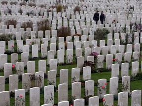 People walk among headstones in the Tyne Cot Cemetery, the largest Commonwealth war grave cemetery in the world.