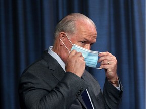 B.C. Premier John Horgan puts on his mask following a Wednesday news conference in Victoria about the province's fall pandemic preparedness plan. Is a fall election part of the plan?