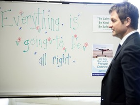 B.C. Minister of Education Rob Fleming walks past a white board that says 'Everything is going to be all right' following an update on return to classes last June.