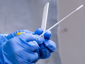 A nurse gets a swab ready at a temporary COVID-19 test clinic.