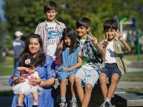 Friba Sarwar Khan, holds 7 month old Parastesh while sitting with her other kids (from left) Adeeb, Setayesh, Ashad and Hadees.