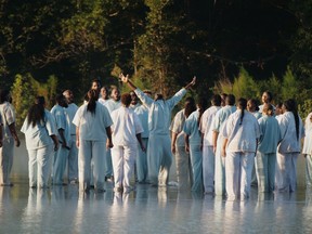 Kim Kardashian West posted photos to Twitter of her husband, Kanye West, leading a Sunday service choir to the middle of a lake.