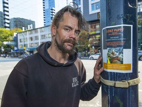 Myke Mclachlin and one of several posters he has made seeking the safe return of his dog, Roach.