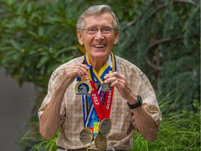 Rod Waterlow, 83, with his marathon medals, including two from the Boston Marathon.