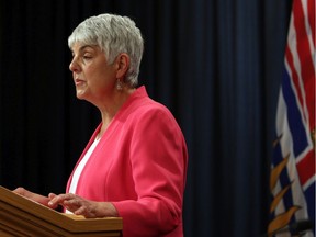 Finance Minister Carole James releases the provincial public accounts report during a news conference in the press gallery at the B.C. Legislature in Victoria on Thursday. The impact of the COVID-19 pandemic has turned B.C.'s budget forecast from black to red.