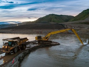 An excavator dredging out a channel at the entrance to one of the river diversion tunnels on B.C. Hydro's Site C dam project on the Peace River near Fort St. John, in August of 2020.