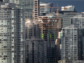 A condo tower under construction is pictured in downtown Vancouver on February 9, 2020. A report commissioned by the B.C. government says insurance premiums for condominium buildings have increased by as much as 40 per cent year over year while deductible costs have tripled.
