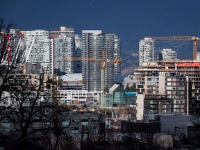 Construction cranes tower above condos under construction near southeast False Creek in Vancouver, on Sunday February 9, 2020. Metro Vancouver home sales hit 3,047 in August at a benchmark price of $1.0387 million, as the housing market continued its recovery from the COVID-19 pandemic.